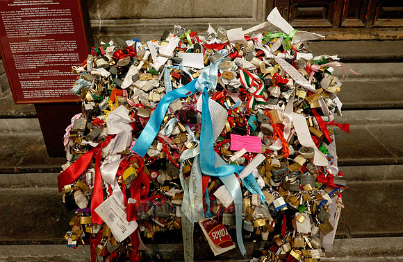 many small padlocks with ribbons and wishes as customs