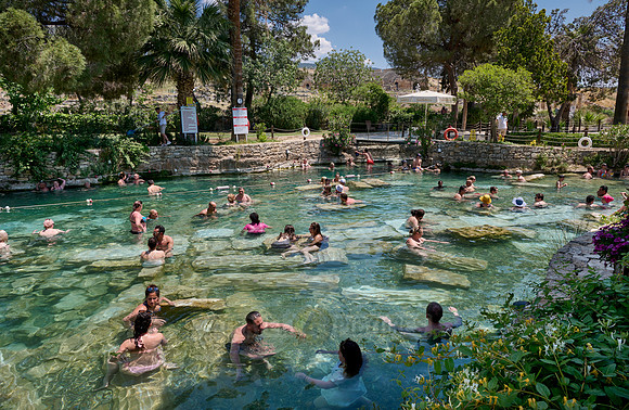 people swimming in natural swimming pool with columns in Greek Hierapolis