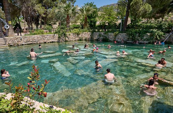 people swimming in natural swimming pool with columns in Greek Hierapolis
