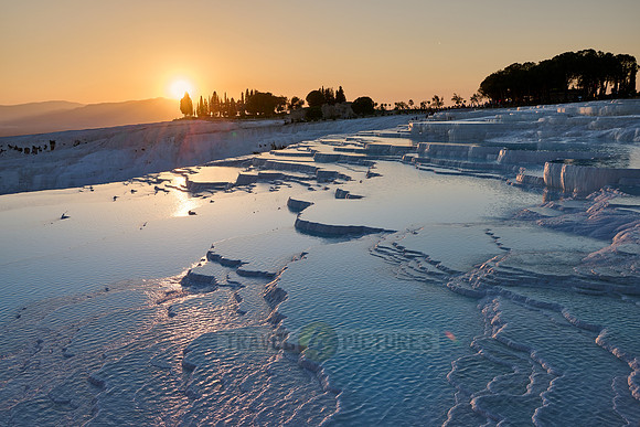 sunset behind Pamukkale travertine terraces