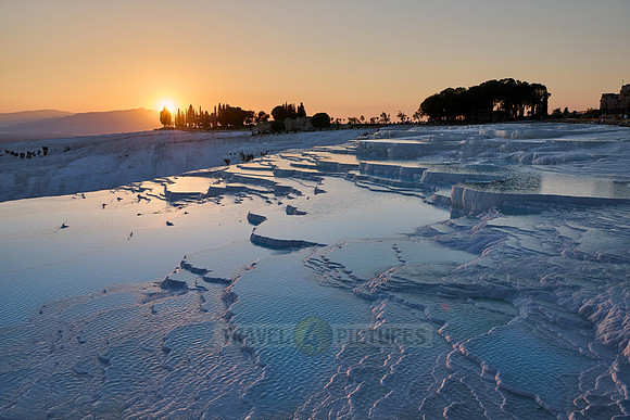 sunset behind Pamukkale travertine terraces
