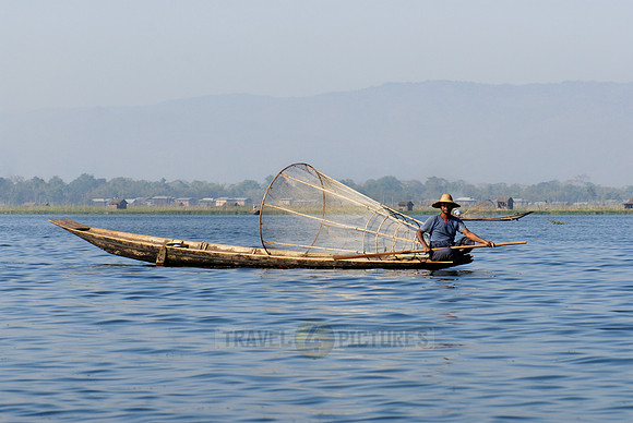 one leg rowing boat with fisherman with his conical trap