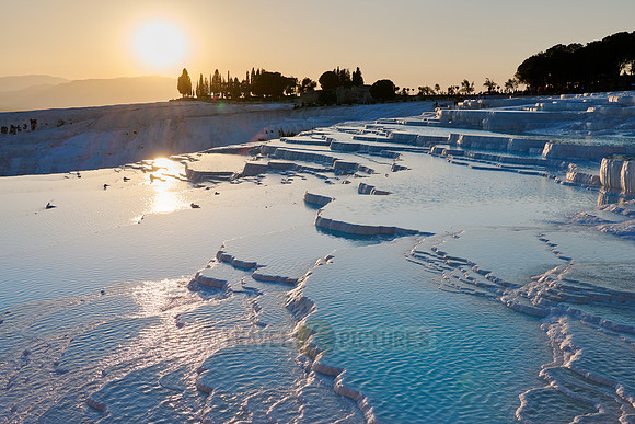 sunset behind Pamukkale travertine terraces