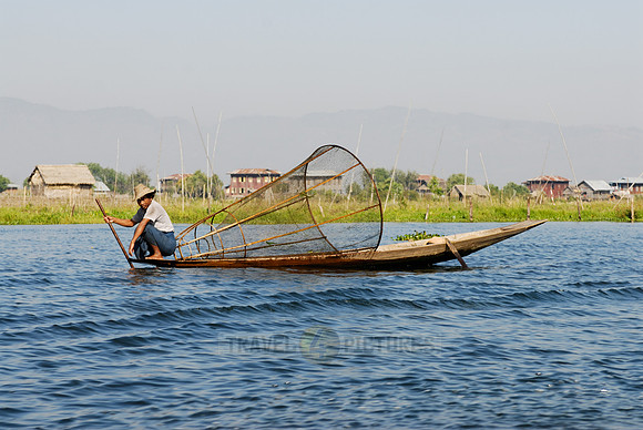 one leg rowing boat with fisherman with his conical trap